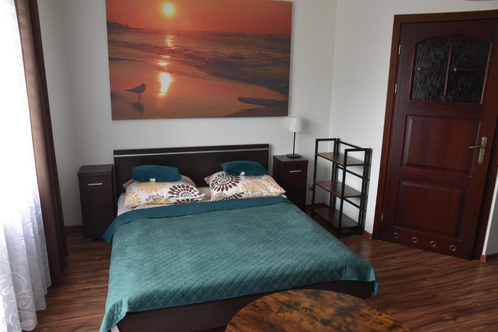 弗瓦迪斯瓦沃沃Willa Wanta的一间卧室配有一张带绿色棉被的床