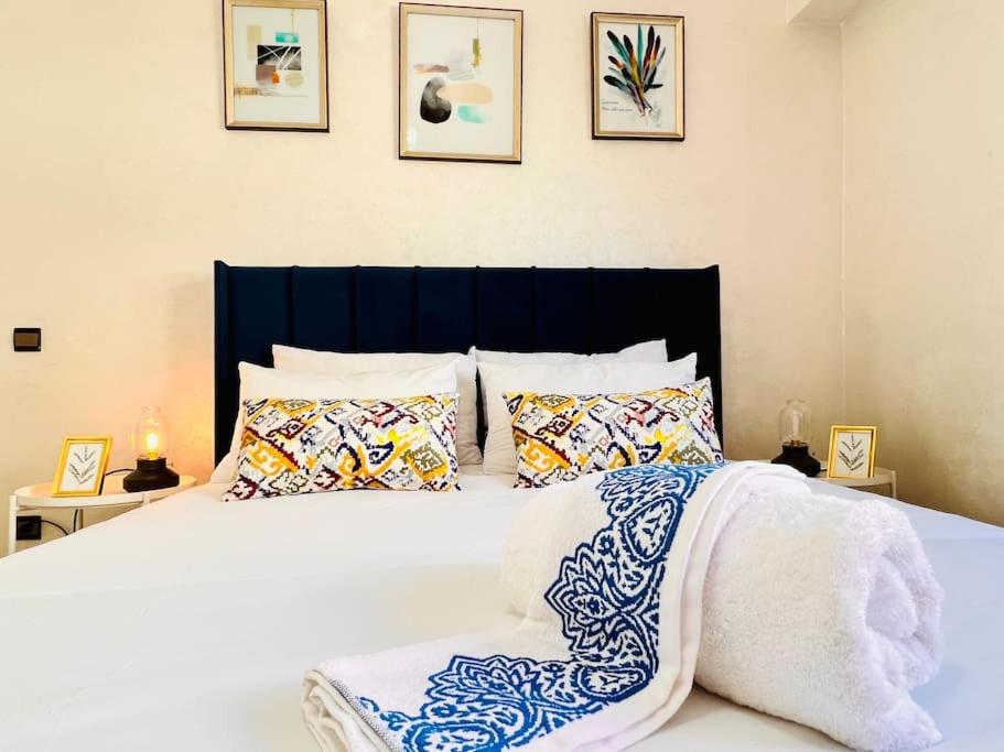 拉巴特Appartement Cosy quartier chic de Rabat的卧室配有带枕头的大型白色床