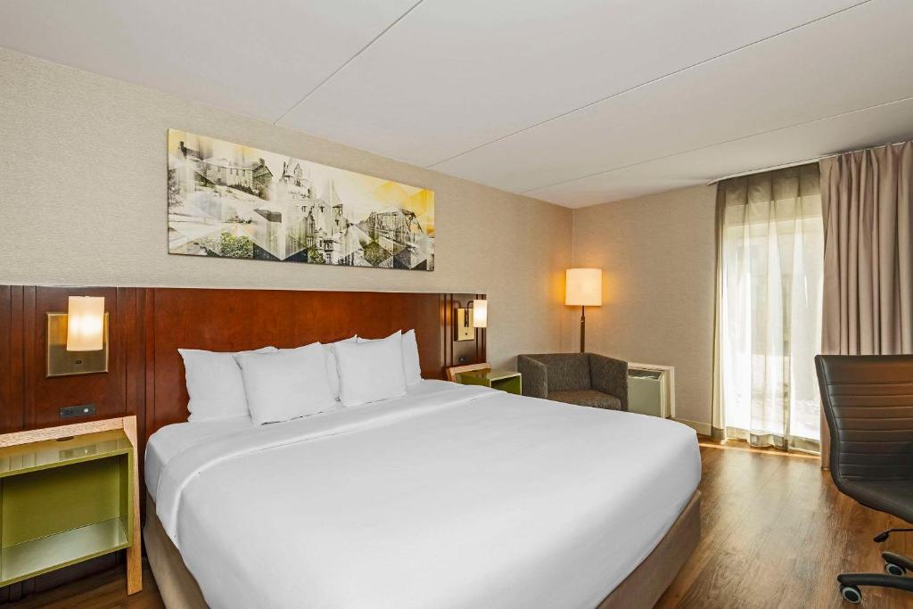 坎布里奇剑桥康福特茵酒店的酒店客房设有一张大床和一张书桌。