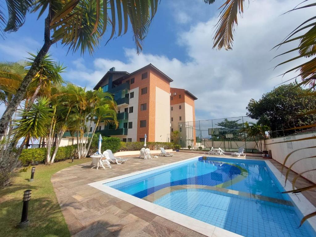 佩鲁伊比Apartamento Peruíbe的一座带度假村的建筑前的游泳池