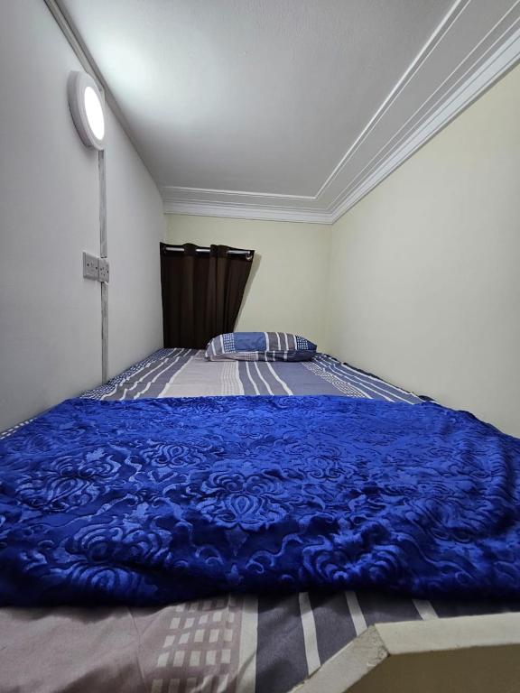 迪拜SKY 9 Hostel的卧室配有蓝色毯子,位于床上