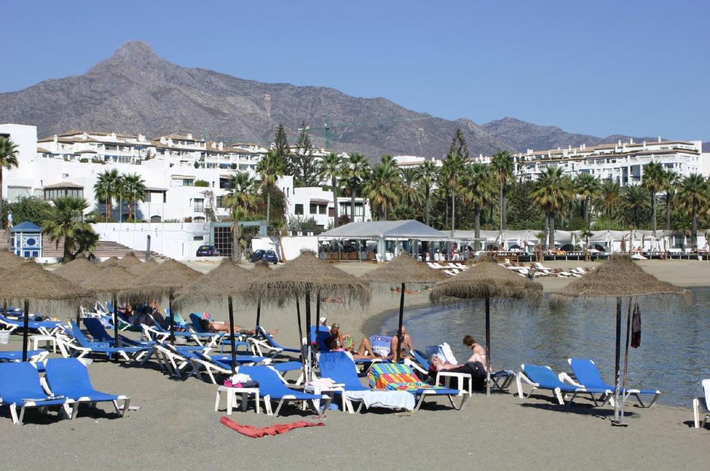 马贝拉Beachfront Puerto Banus的海滩上的一组椅子和遮阳伞