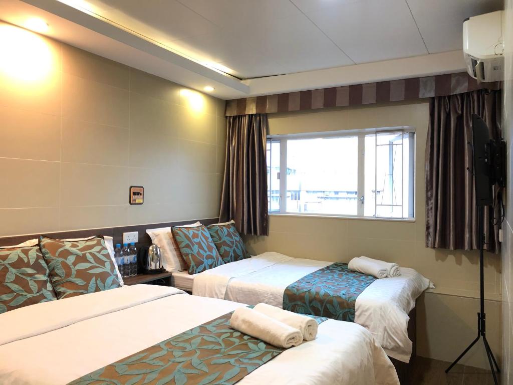 香港香港星星旅馆 b&b的酒店客房设有两张床和窗户。