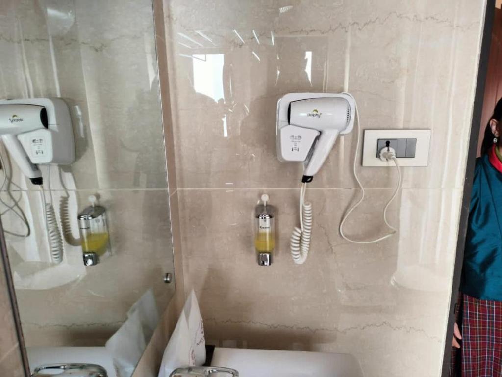帕罗Nirvana Inn的一间带两个盥洗盆的浴室和墙上的一部电话