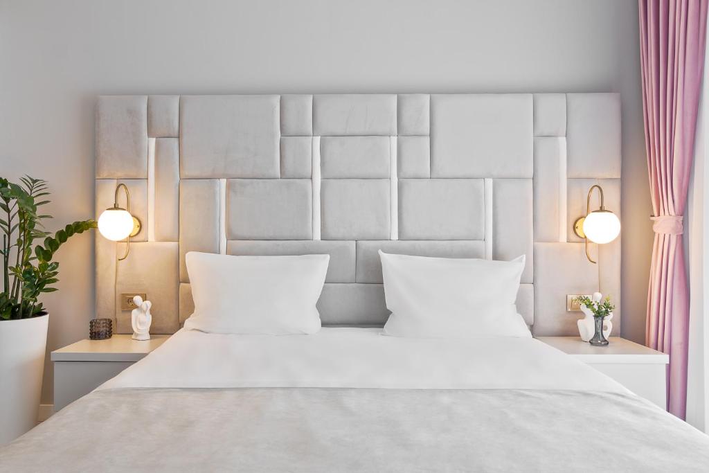 奥拉迪亚Andreea Studio的卧室配有一张带两个白色枕头的大白色床