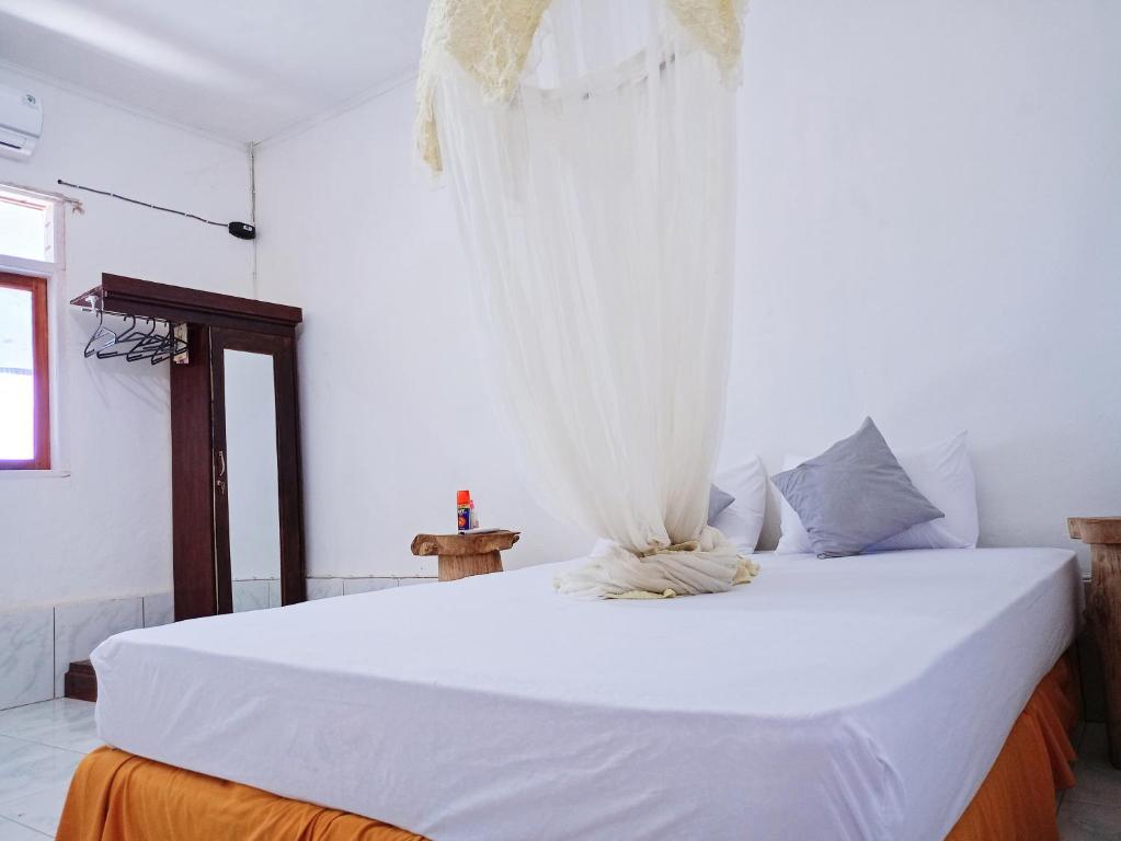 HuuRocky homestay lakey nangas beach的卧室配有带窗帘的大型白色床