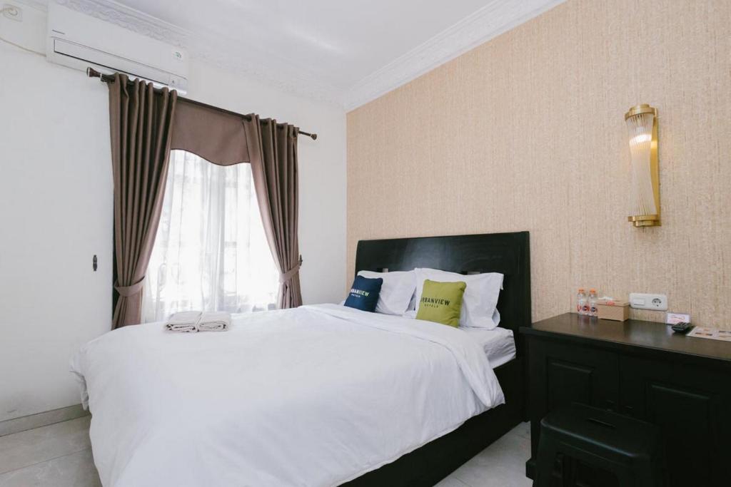 DauUrbanview Hotel Sultan Palace Malang by RedDoorz的卧室设有一张白色大床和一扇窗户。