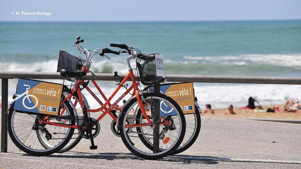 安格雷COSY ROOM PRIVATE BATH AND GARDEN的停在海滩围栏旁的自行车