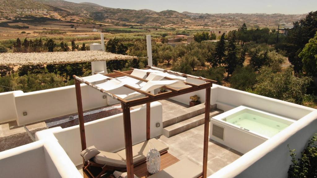 纳克索乔拉Ninemia Naxos Suites的阳台享有带热水浴池的别墅的景致。