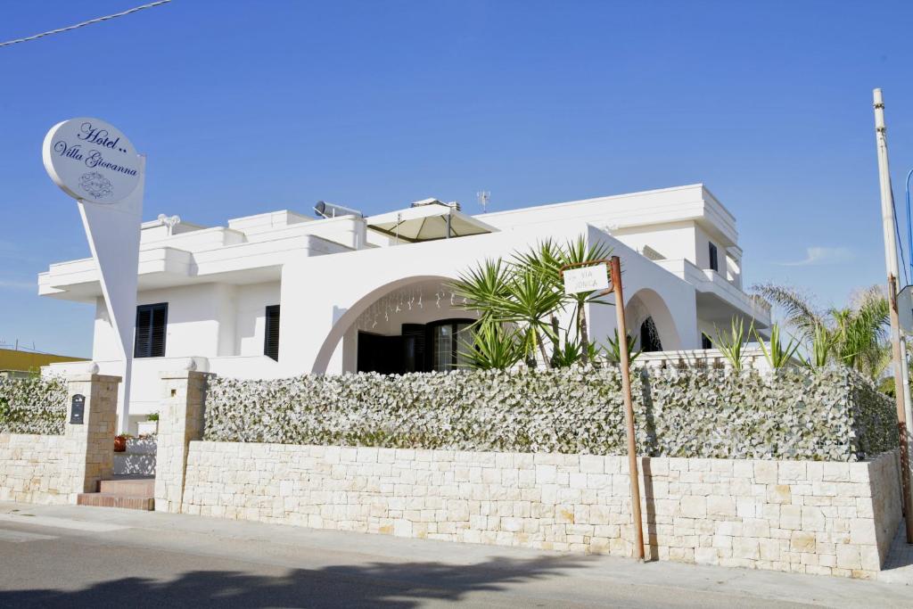 托雷苏达Hotel Villa Giovanna的白色的房子,有石墙和围栏