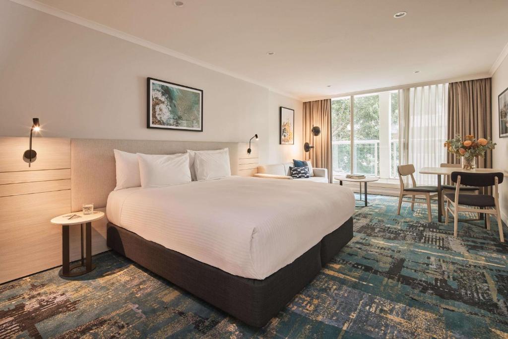 悉尼Rydges Darling Square Apartment Hotel的酒店客房设有一张大床和一张桌子。