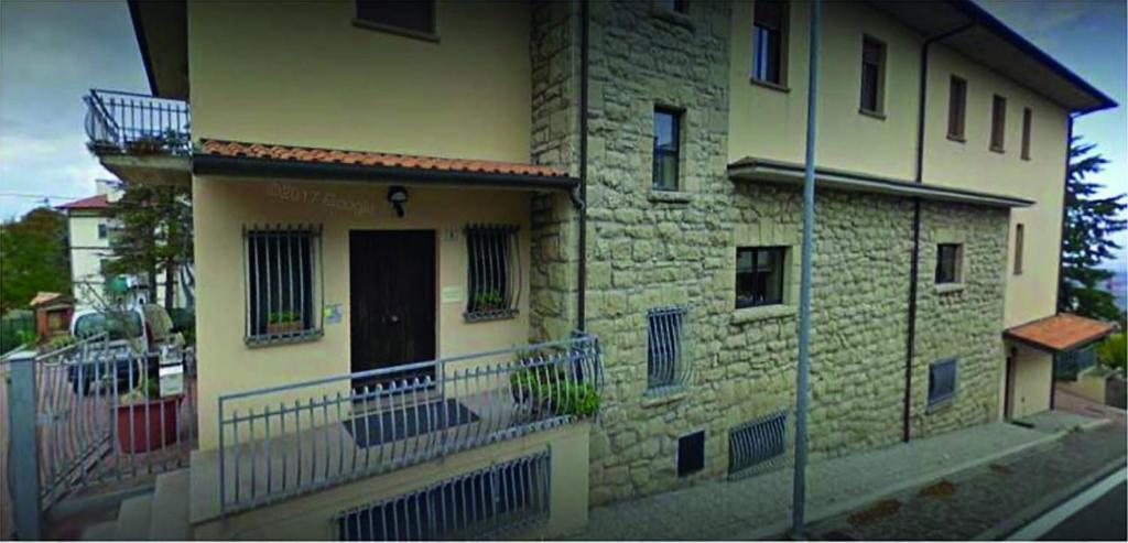 瓦拉爪贡Stabat Mater Casa di Preghiera的一面是一栋砖砌建筑,旁边设有阳台