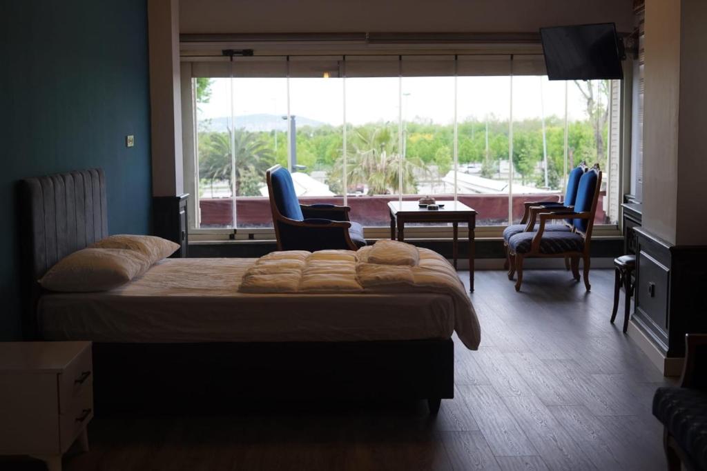 伊斯坦布尔Yalı Beach Houses的一间卧室配有床和椅子以及大窗户