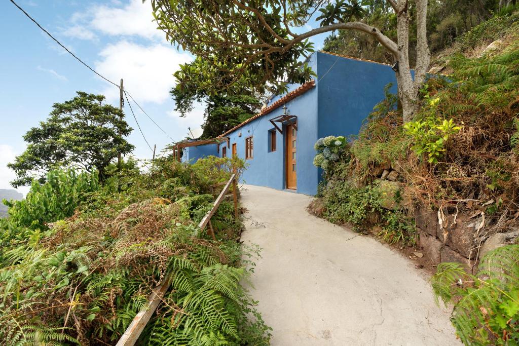 圣克鲁斯-德特内里费Casa Azul del Roque Negro的土路旁山丘上的蓝色建筑
