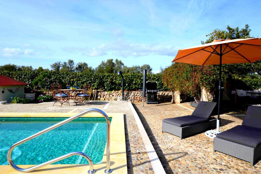 科斯提克斯Casa con piscina en bonito entorno Mia的一个带遮阳伞和椅子的游泳池