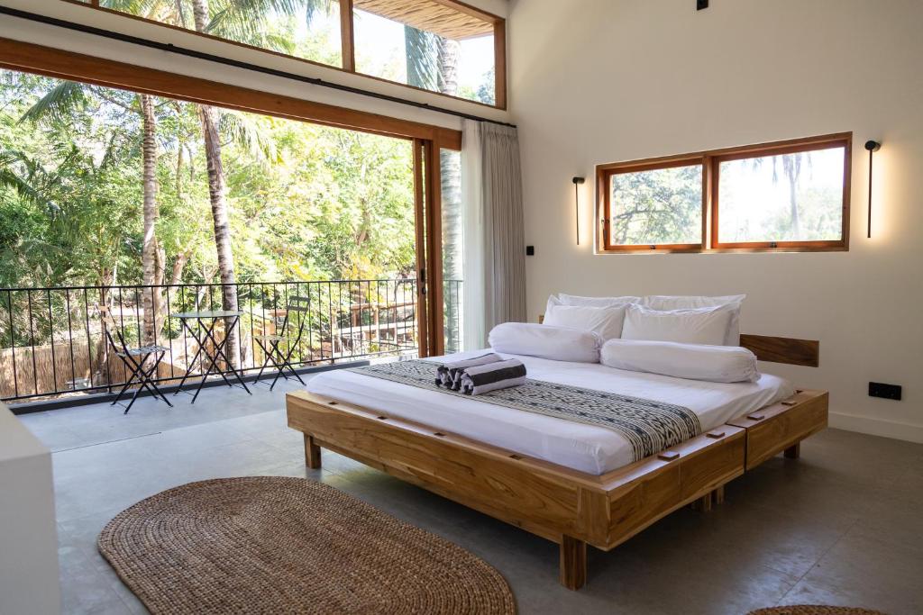 吉利阿尔Villa Luna - Gili Air的一间带大床的卧室和一个阳台