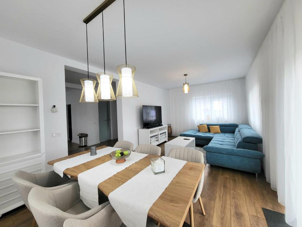 BaciuSunset House spacious 3 bedrooms Baciu Cluj的客厅配有桌子和蓝色沙发