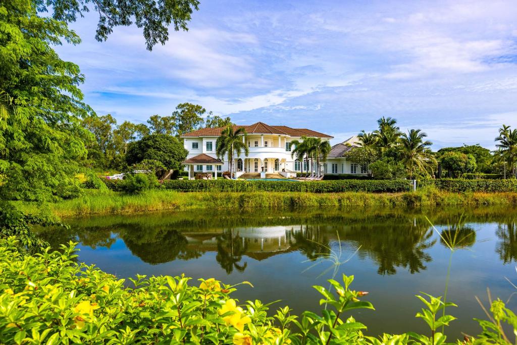 Ban Nong SaiThe White House, Palm Hills Golf and Country Club的前面有池塘的房子