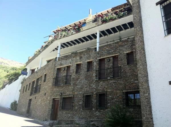 特雷韦莱斯APARTAMENTOS SIETE LAGUNAS的一座大型砖砌建筑,阳台上有人