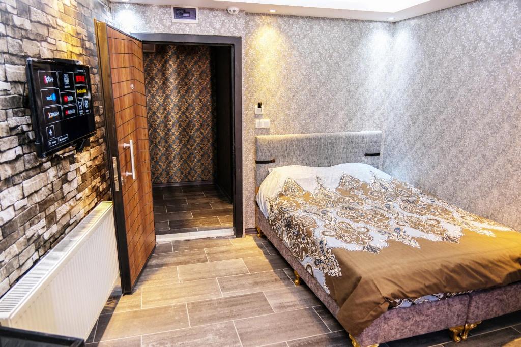 伯萨ROYAL SUİT的卧室,卧室配有一张床,卧室位于带门的房间