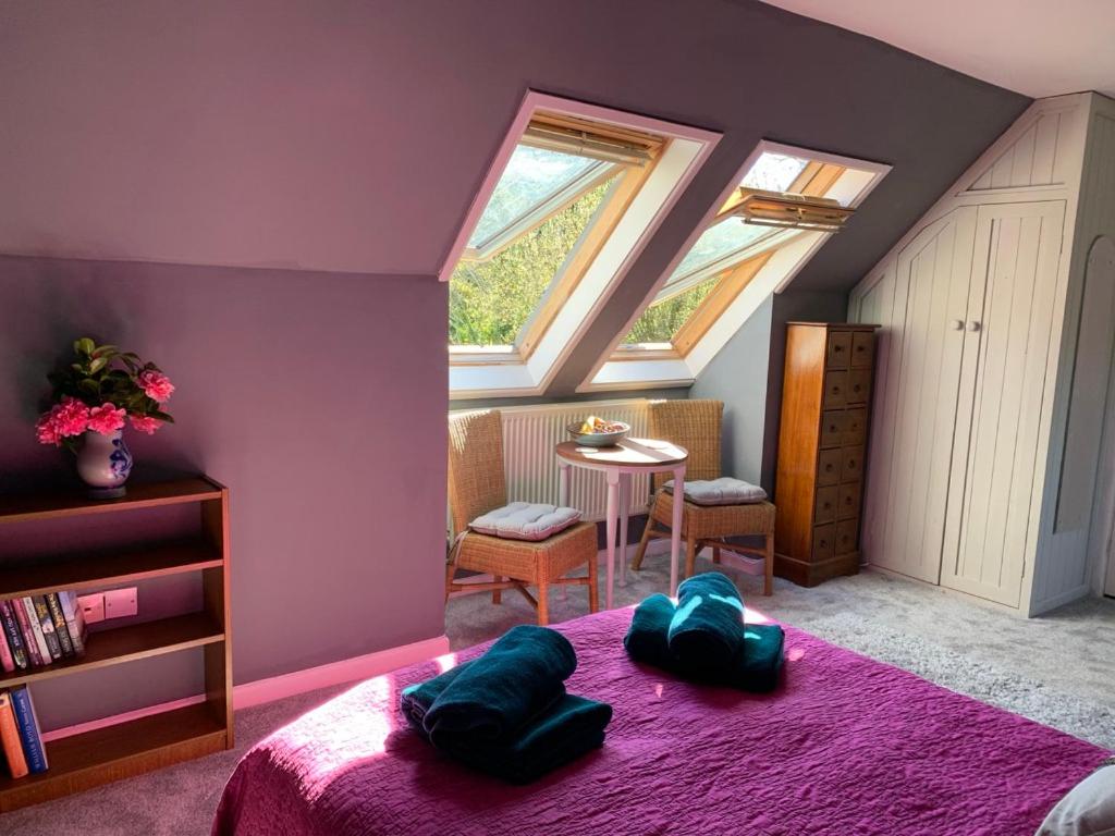 康斯坦丁Silverspring Farm En suite的一间卧室设有紫色的房间,配有一张床和一张桌子