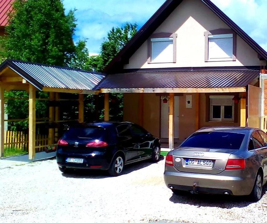 扎布利亚克Apartmani Popovic Lux的两辆汽车停在房子前面