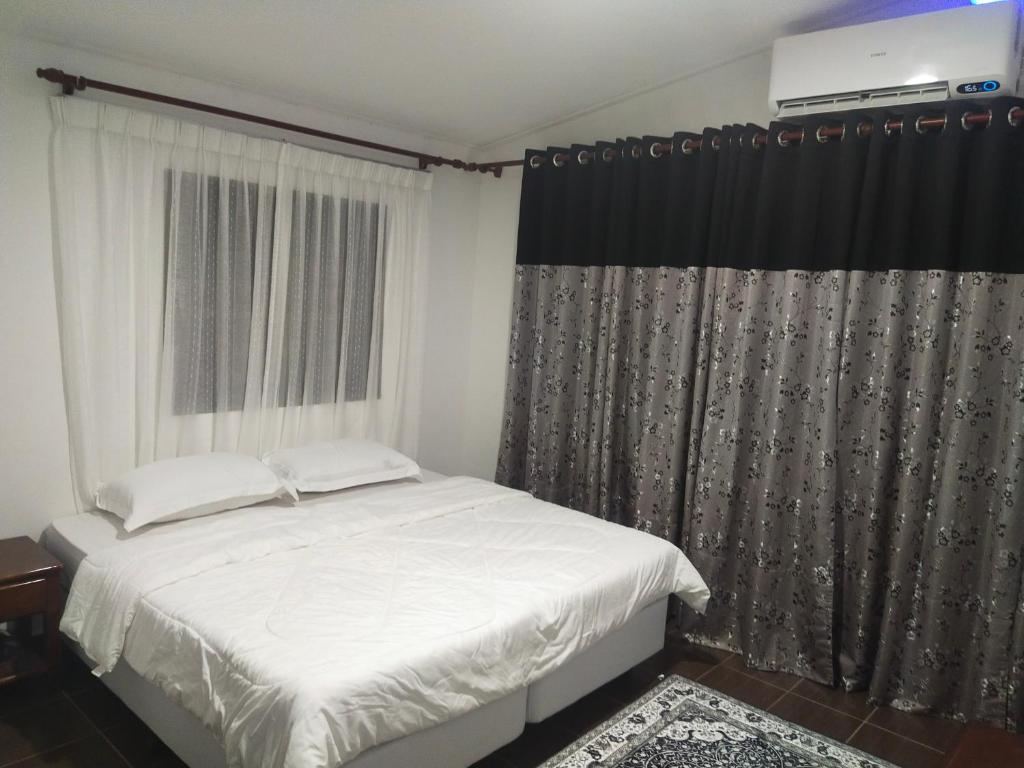 Nor@az RoomeStay的卧室配有白色的床和窗户。