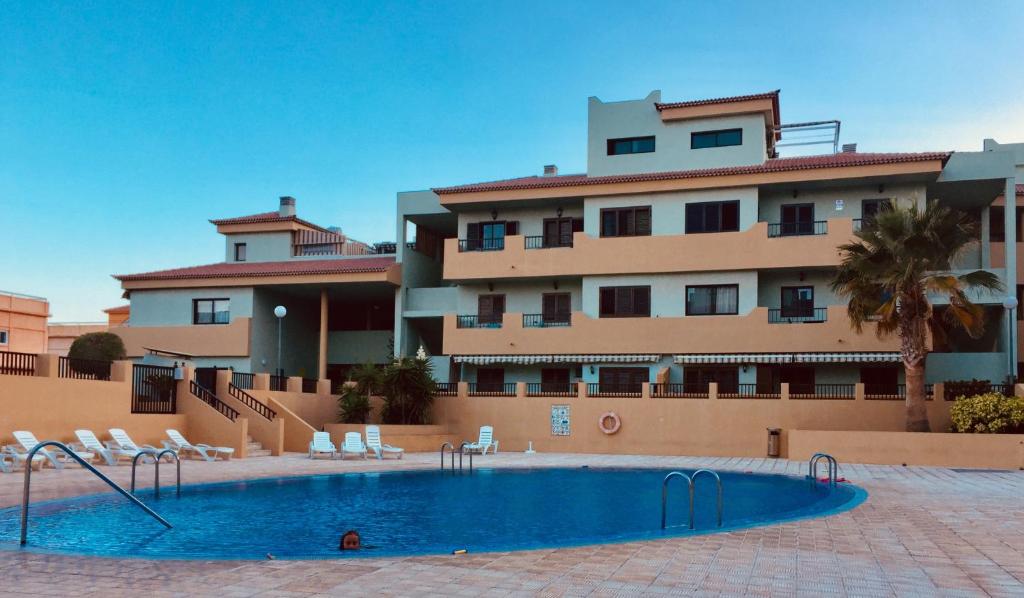 圭马尔港Apartamento La Marquesa Beach的大楼前设有游泳池的酒店