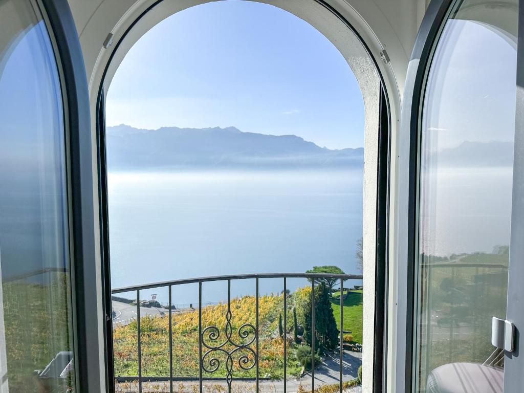PuidouxRoom with 360° view overlooking Lake Geneva and Alps的享有海景的拱形窗户