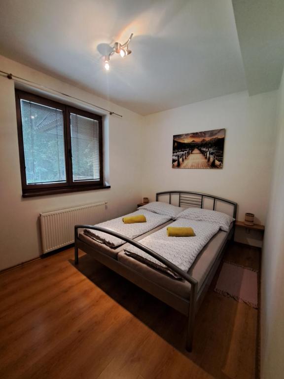 高塔特拉山Apartmán Severanka的一间卧室配有一张带两个黄色枕头的床