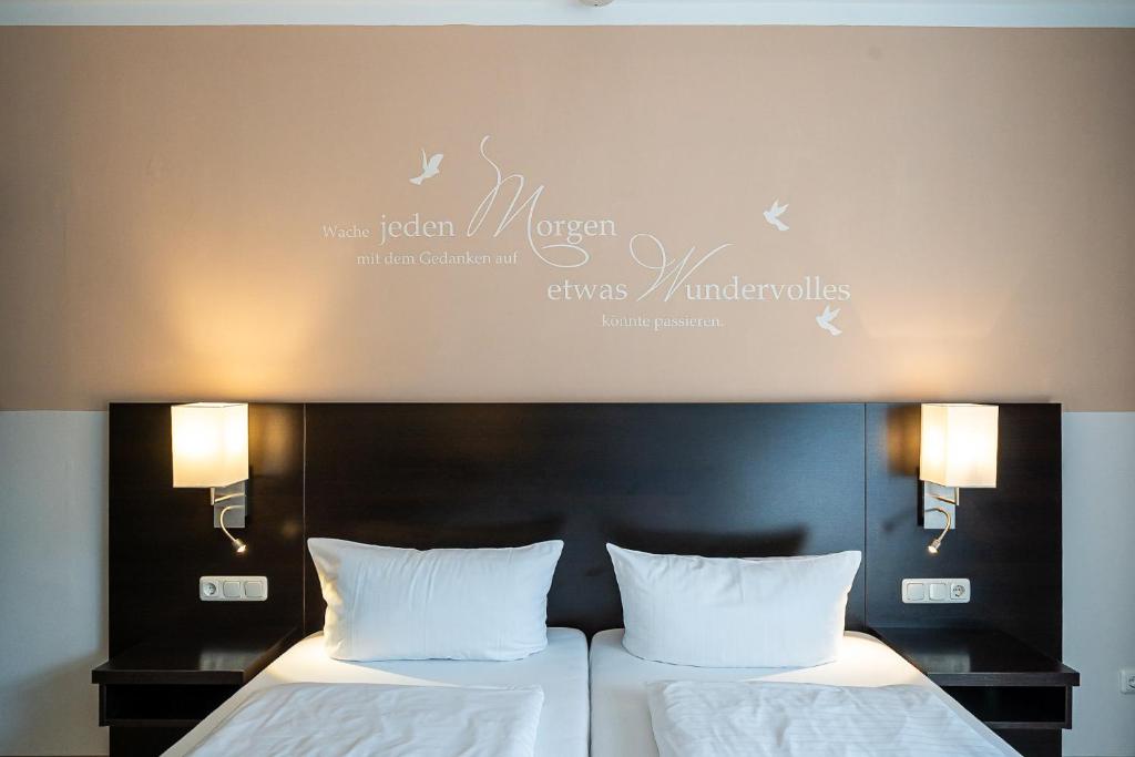 威廉港Hotel Banter Hof的酒店的客房内设有两张带白色枕头的床。