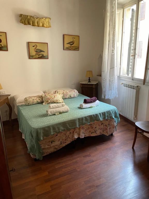 佛罗伦萨Residenza dei Medici Palace Matilde的一间卧室配有一张床,上面有两条毛巾