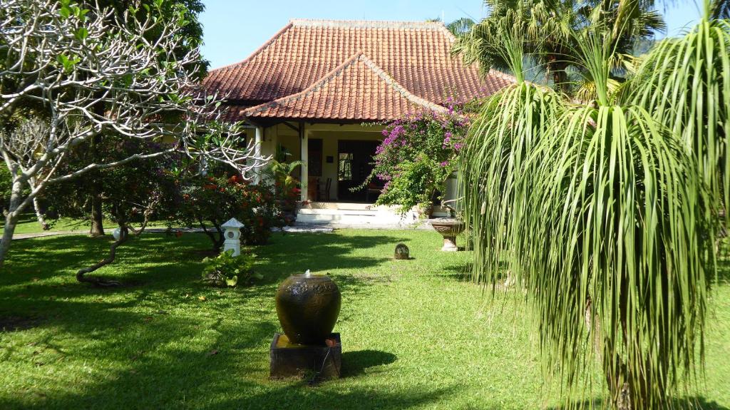 KalibaruRumah Kita Villa/hotel的前面有棕榈树的房子