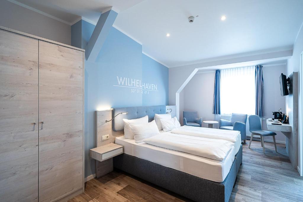 威廉港Wilhelms HAVEN HOTEL的一间卧室配有一张大床和一张书桌