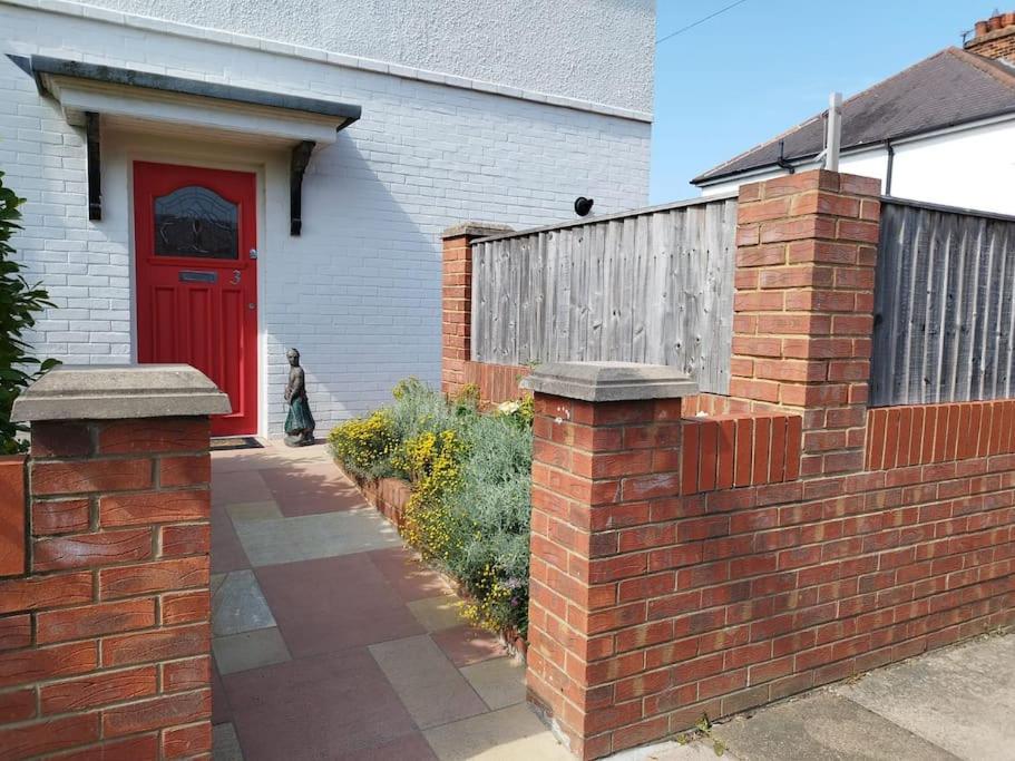 Great CoatesCosy Modern Grimsby Home的建筑前有红门的砖墙