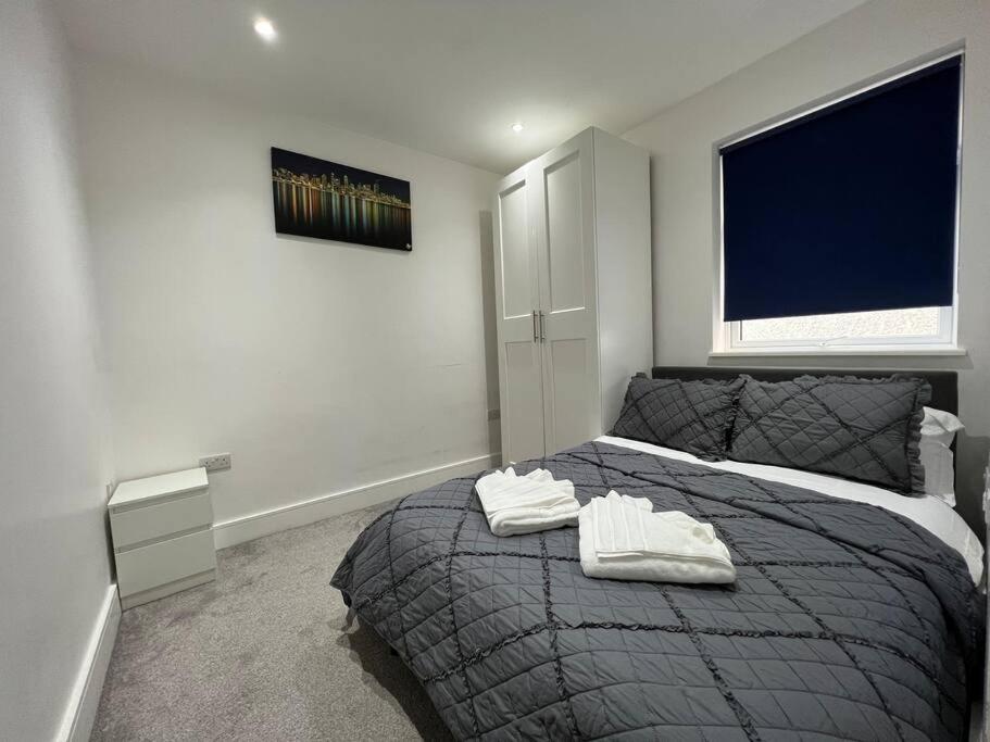 亨顿Star London Bell Lane 3-Bed Oasis with Garden的一间卧室配有一张床,上面有两条毛巾