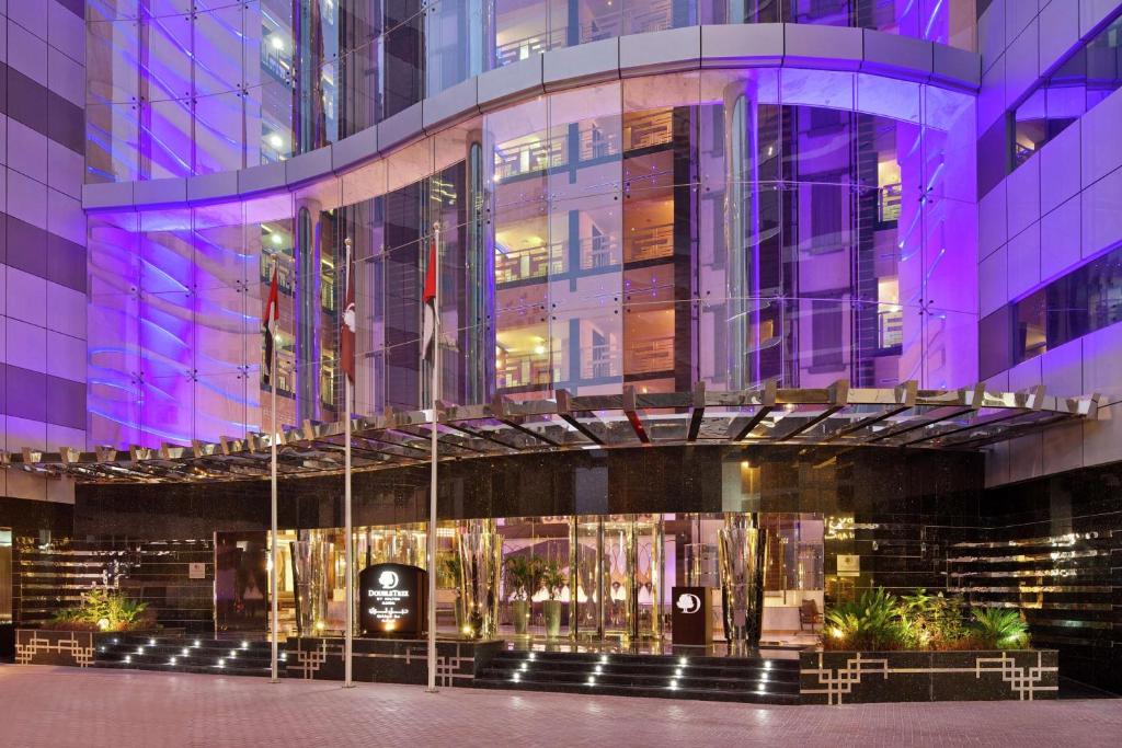 迪拜DoubleTree by Hilton Hotel and Residences Dubai – Al Barsha的夜间建筑物入口的 ⁇ 染