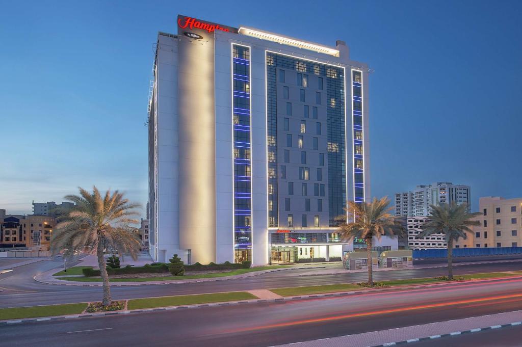 迪拜迪拜机场汉普顿酒店 的一座棕榈树城市的大建筑