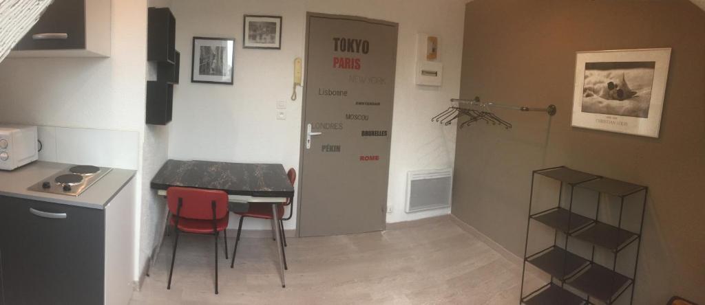 贝尔福Studio moderne, étage 3, avec literie de qualité prémium的一个带桌子和两张红色椅子的小厨房