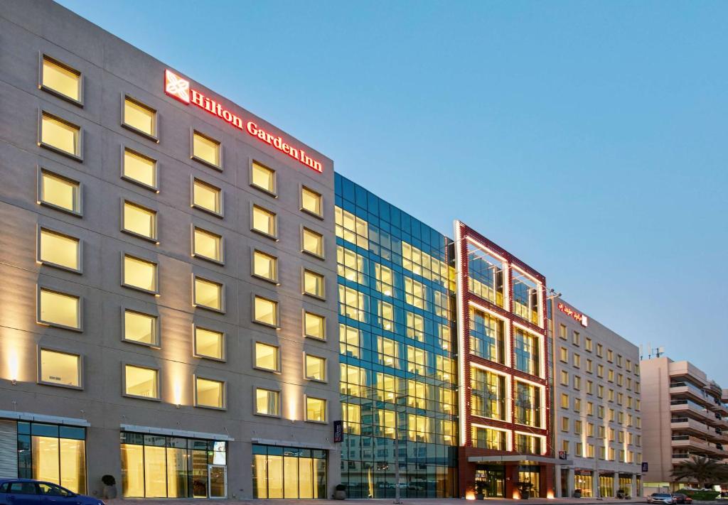 迪拜Hilton Garden Inn Dubai, Mall Avenue的街道上有许多窗户的大建筑