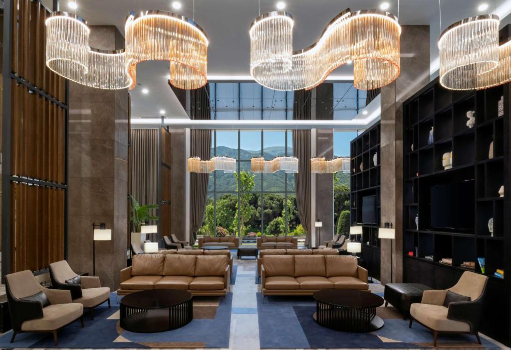 马尼萨DoubleTree by Hilton Manisa的大堂配有沙发、椅子和吊灯