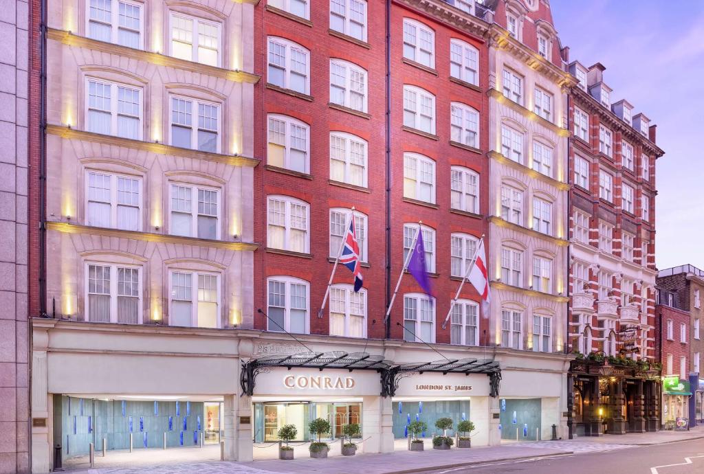 伦敦伦敦圣詹姆斯康拉德酒店的一座红色的大建筑,上面有两面旗帜