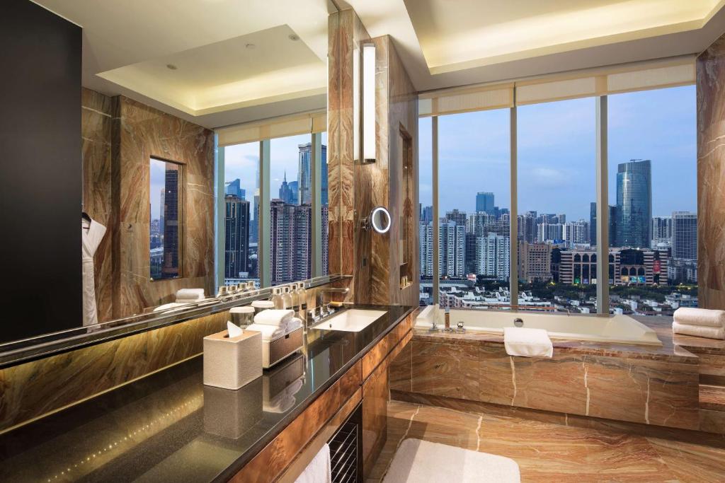 广州广州天河希尔顿酒店 - 免费广交会穿梭巴士 - 采购商办证点的带浴缸的浴室和大窗户