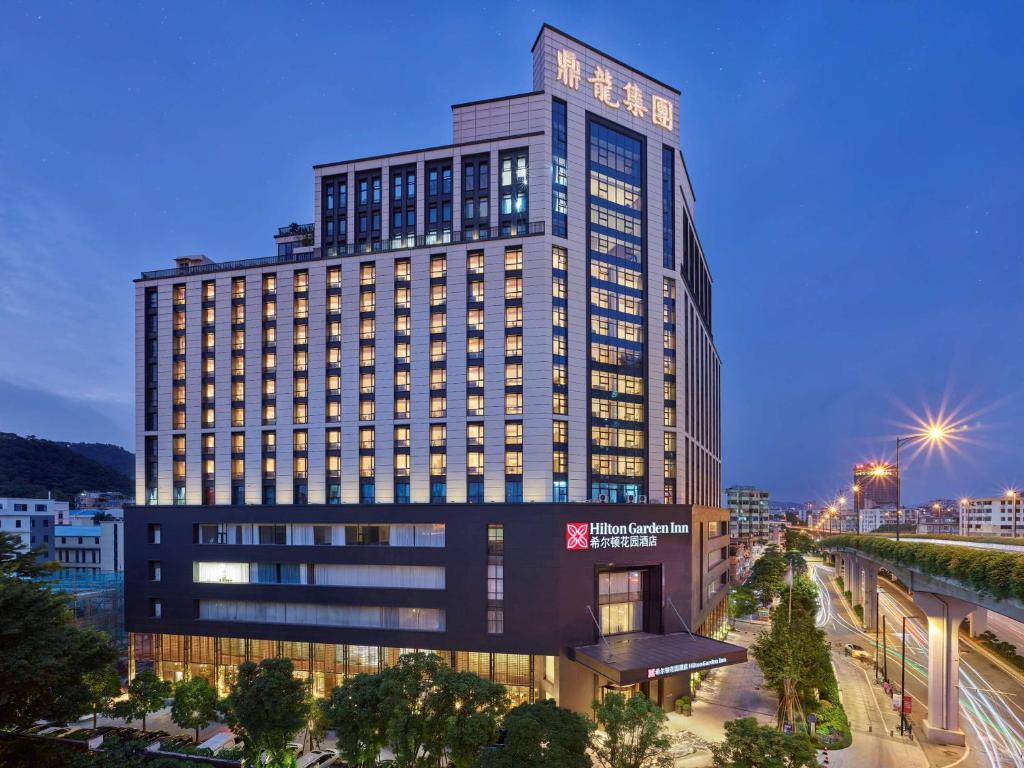 广州Hilton Garden Inn Guangzhou Tianhe- Free Canton Fair Shuttle Bus的夜幕 ⁇ 染高楼