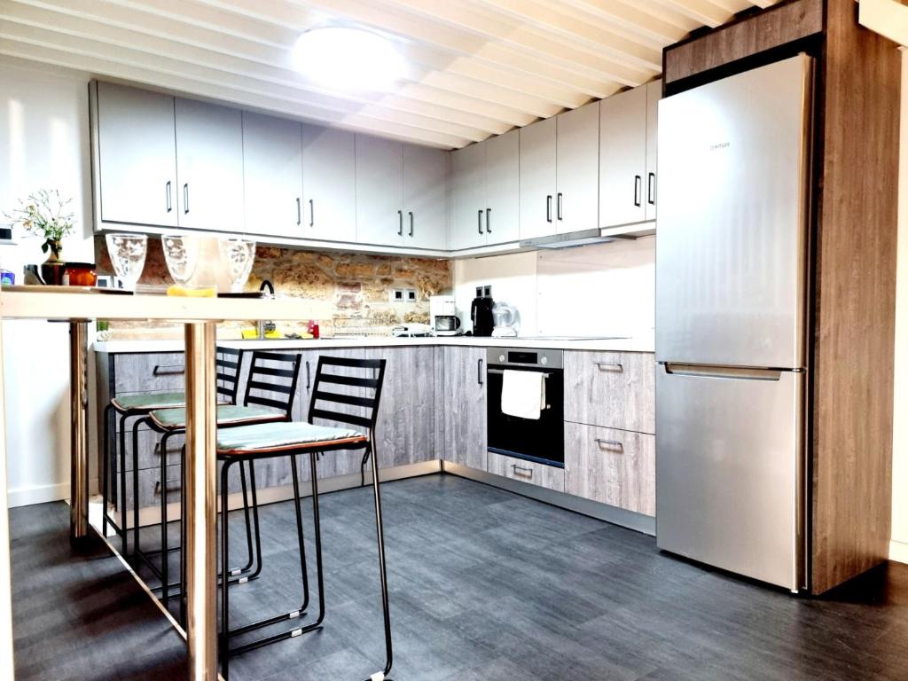 希俄斯Castle luxury home的厨房配有白色橱柜、桌子和冰箱。