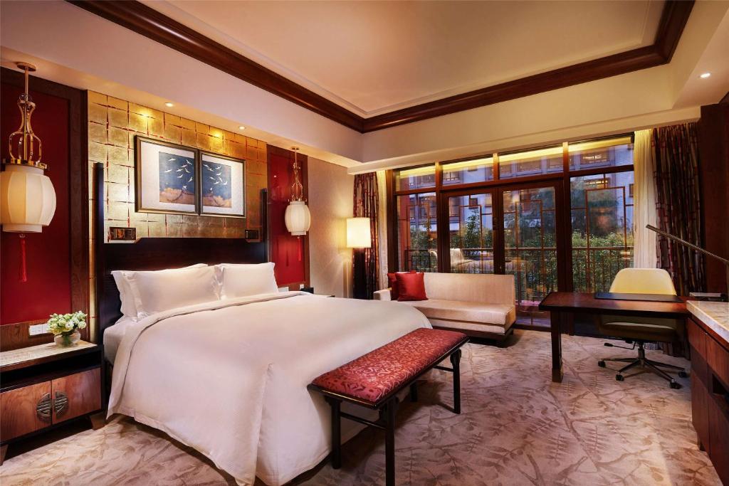 滨海新区天津生态城世茂希尔顿酒店的卧室配有一张白色大床和一张书桌