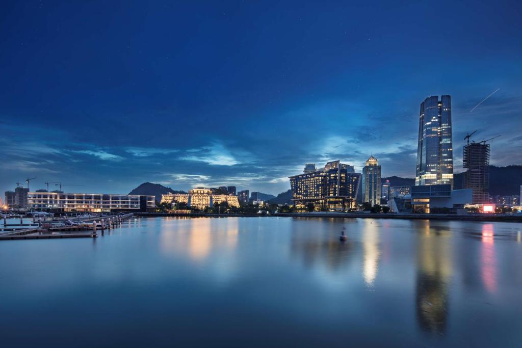 深圳深圳蛇口希尔顿南海酒店的城市天际线,夜晚有一大片水