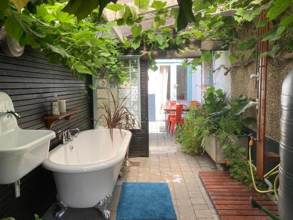 朴次茅斯The Vineyard (Home of the think pod)的带浴缸、水槽和植物的浴室