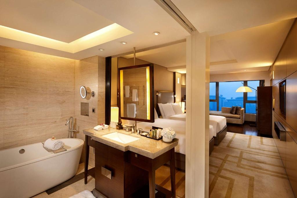 北京北京王府井希尔顿酒店的一间带床、浴缸和水槽的浴室