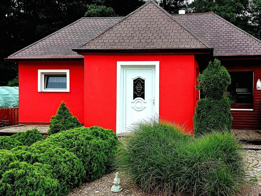新瓦尔普诺holiday home, Nowe Warpno的院子里有白色门的红色房子